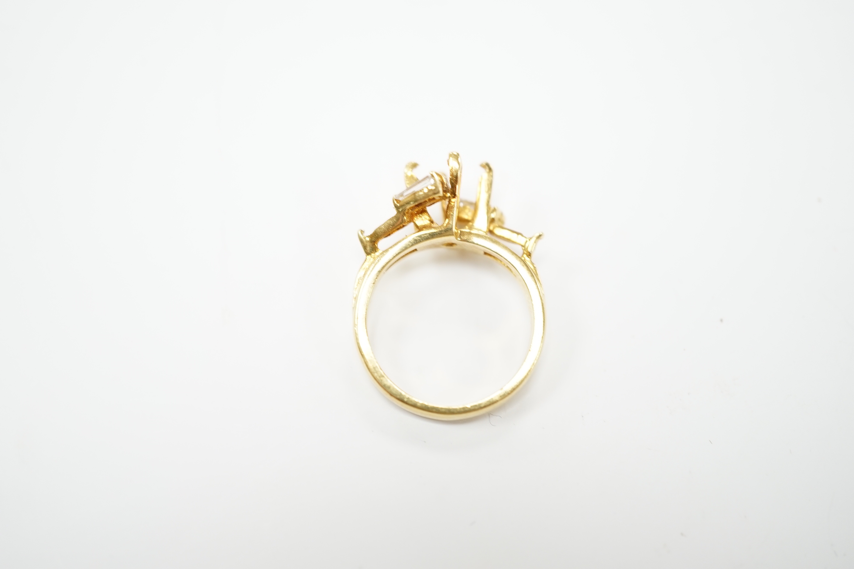 A modern 18ct gold and four stone trapeze cut diamond set crossover ring, size J, (central stone missing), size I/J, gross weight 4.6 grams.